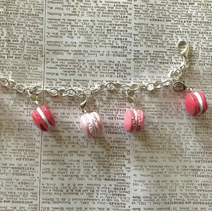 Pink Macarons hanging off of a silver chain bracelet